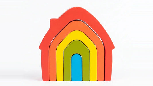 Cinq maisons en bois emboîtées l'une dans l'autre, rouge, orange, jaune, verte et bleue, sur un fond clair