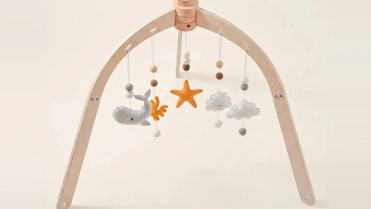 Arche d'éveil en bois en forme de dôme, avec une baleine, une étoile, des nuages et du corail en feutrine suspendus