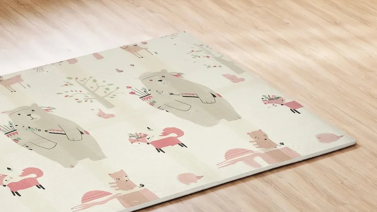 Tapis d'éveil pliable rectangulaire imprimé d'ours et de renards, posé sur un parquet près de l'angle d'une pièce