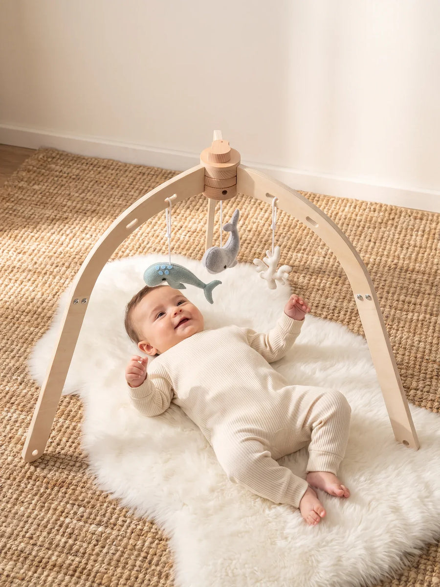 Bébé allongé sur le dos sous l’arche
