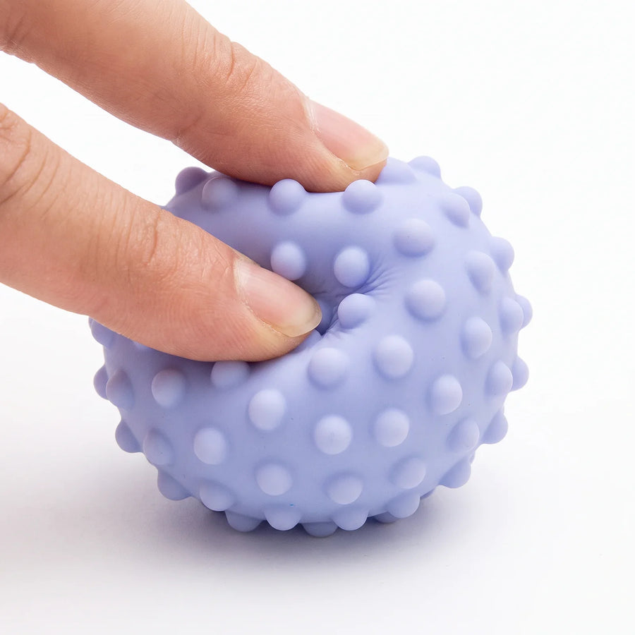 Une balle pressée entre deux doigts