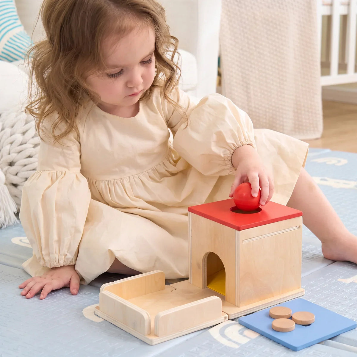 Une enfant pose la balle rouge sur la boîte de permanence
