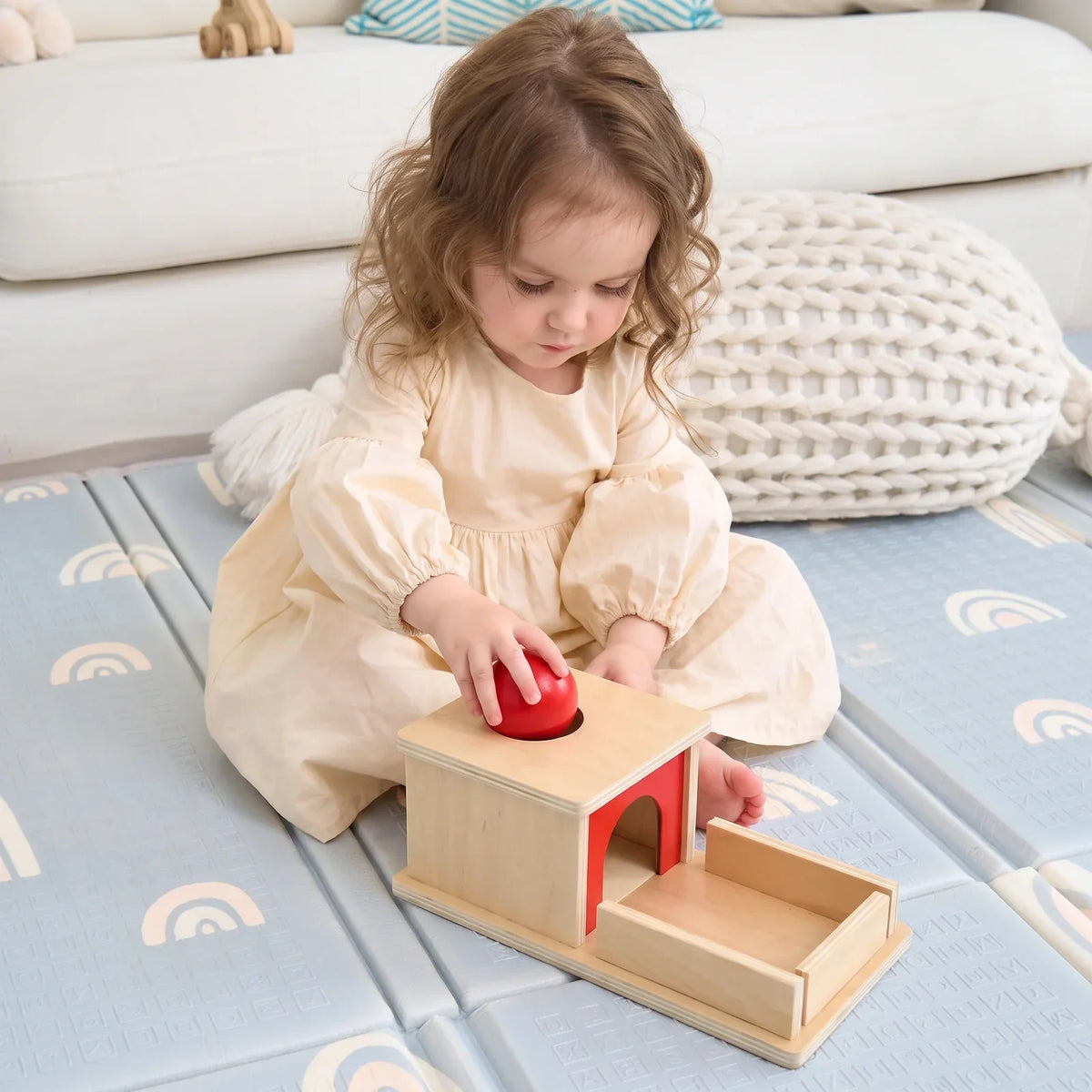 Un enfant joue avec la boîte à balle en bois