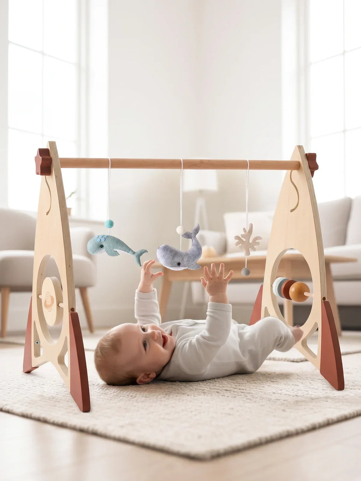 Bébé allongé sur le dos sous l'arche d'éveil, dans un salon