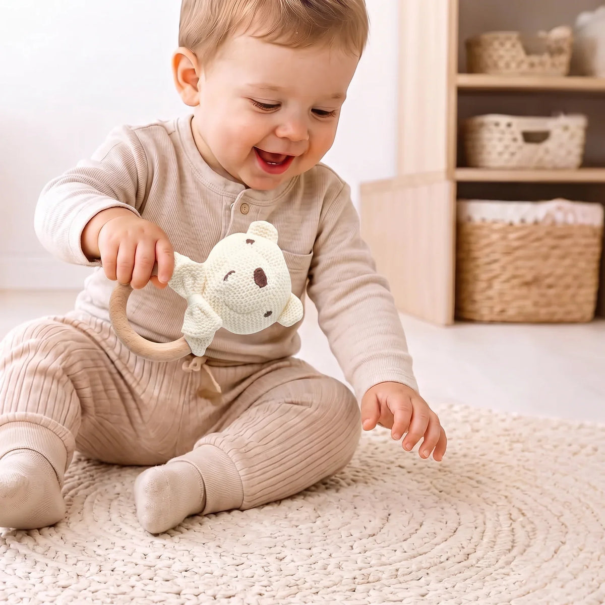 Un enfant tient le hochet crochet par son anneau en bois
