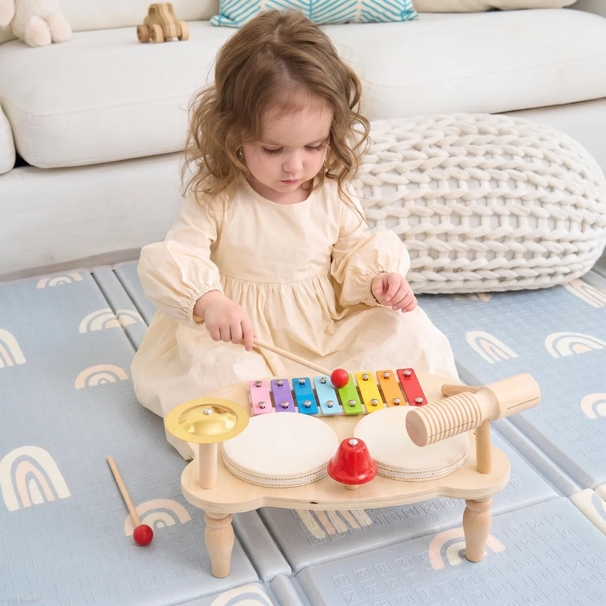 Une enfant assise frappe les lames du xylophone avec une baguette